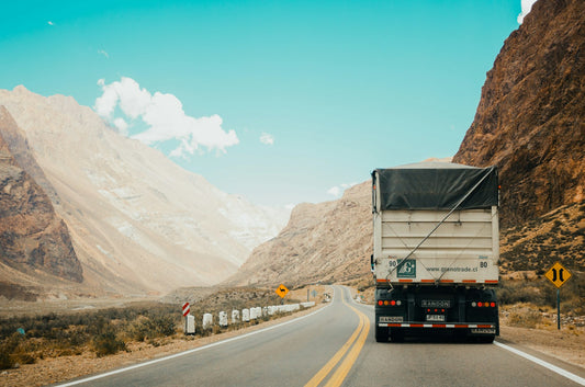 truck in between the mountains — cross-border freight (Unsplash, Rodrigo Abreu)