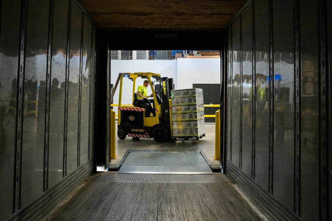 man carrying box using fork liftr — cross-border freight (Unsplash, Elevate)