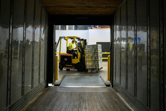 man carrying box using fork liftr — cross-border freight (Unsplash, Elevate)