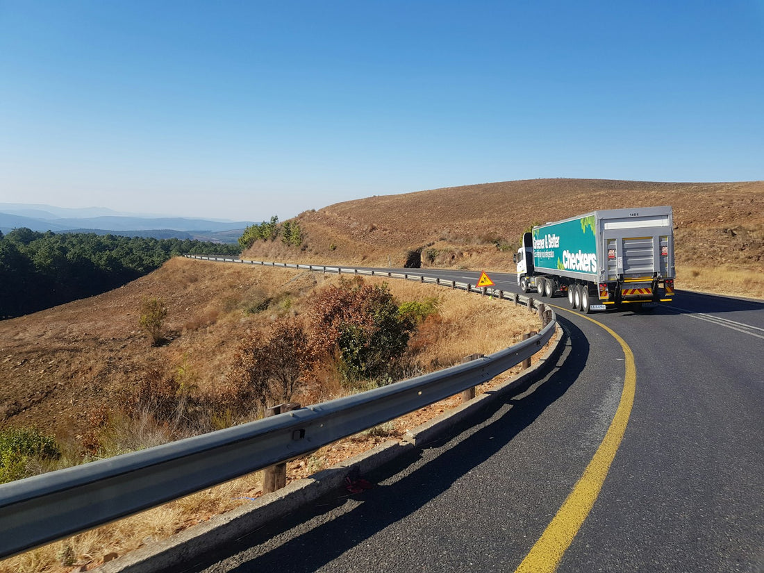 white and blue truck on road during daytime — cross-border freight (Unsplash, Tiry Nelson Gono)