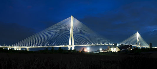 Cable-stayed international bridge lit at night on the Canada-US border corridor